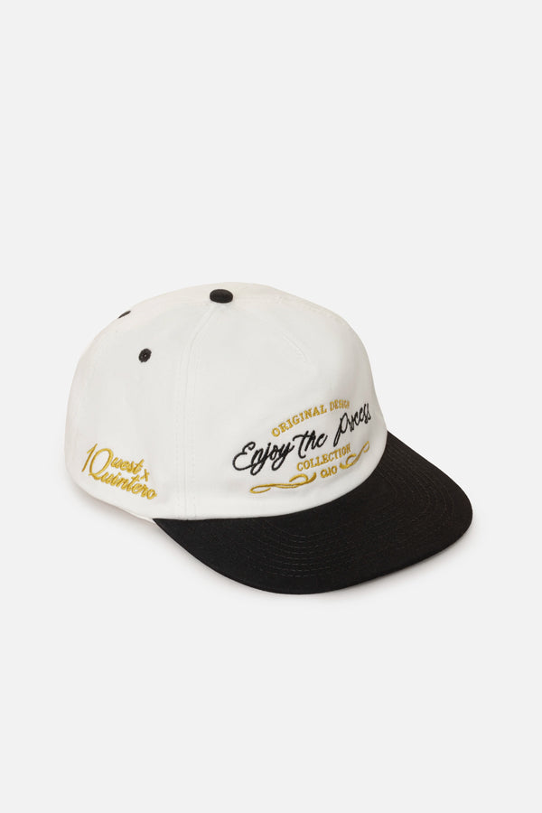 GORRA BEISBOLERA EN BLOQUES DE COLOR BEIGE CON BORDADO MARCA QUEST X JUAN FERNANDO QUINTERO