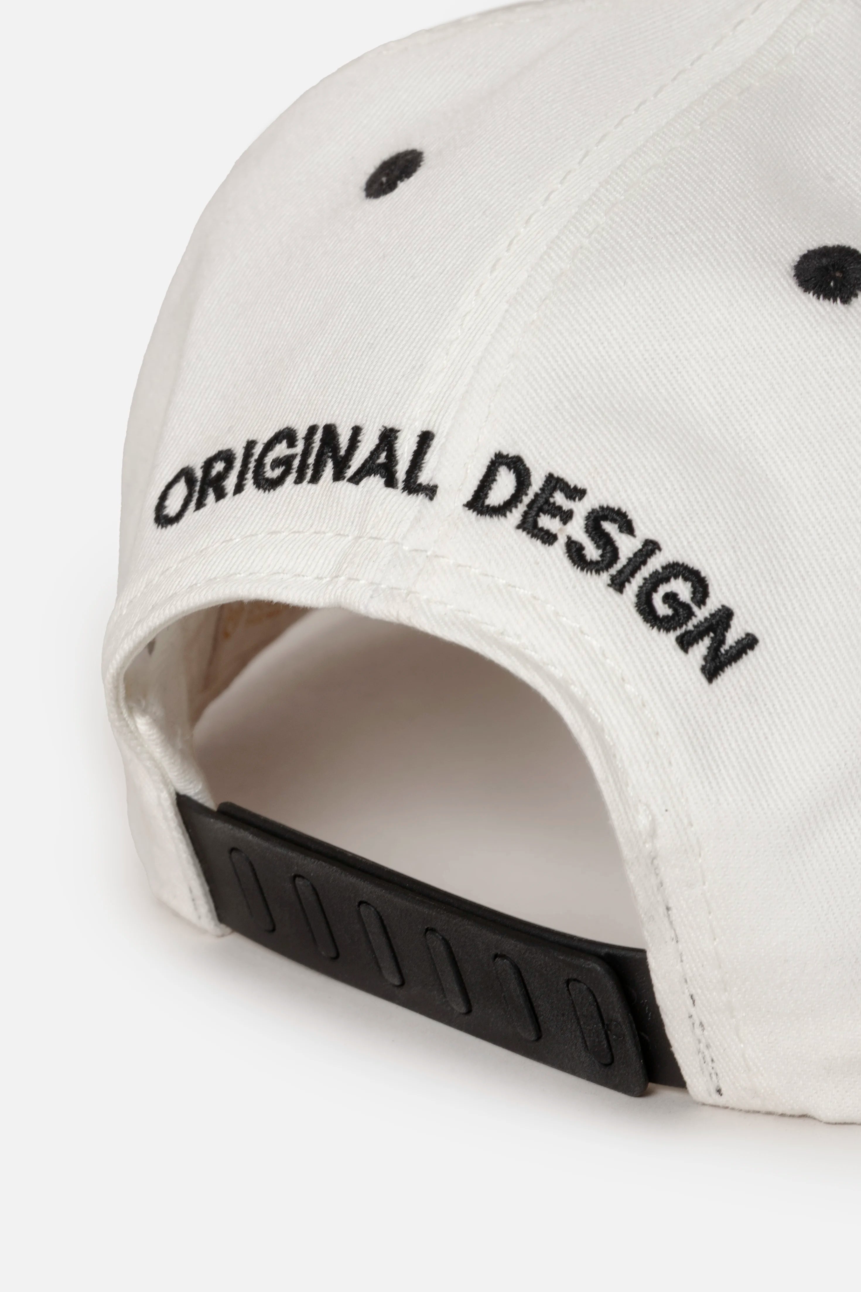 GORRA BEISBOLERA EN BLOQUES DE COLOR BEIGE CON BORDADO MARCA QUEST X JUAN FERNANDO QUINTERO