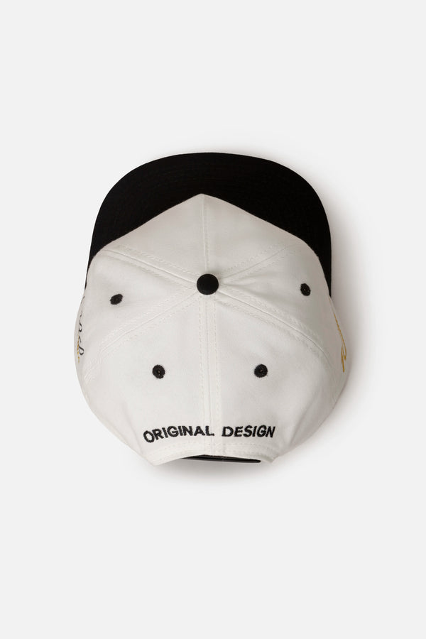 GORRA BEISBOLERA EN BLOQUES DE COLOR BEIGE CON BORDADO MARCA QUEST X JUAN FERNANDO QUINTERO