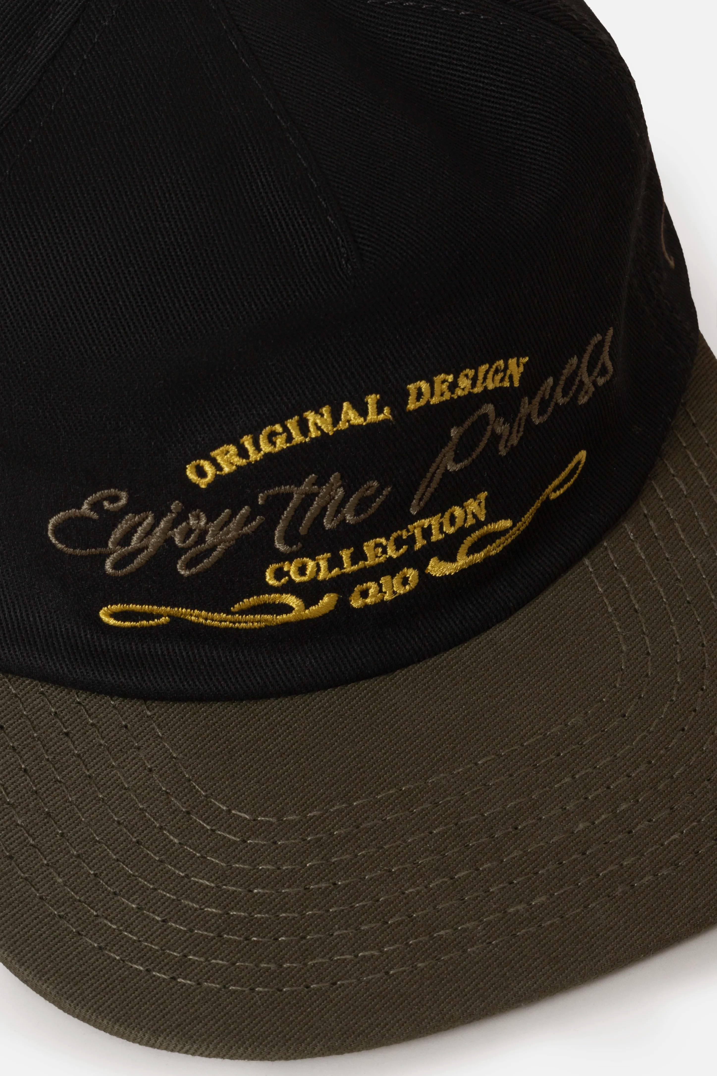 GORRA BEISBOLERA EN BLOQUES DE COLOR CON BORDADO VERDE MARCA QUEST X JUAN FERNANDO QUINTERO