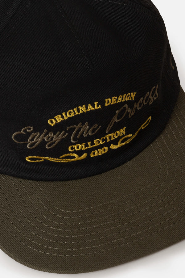 GORRA BEISBOLERA EN BLOQUES DE COLOR CON BORDADO VERDE MARCA QUEST X JUAN FERNANDO QUINTERO