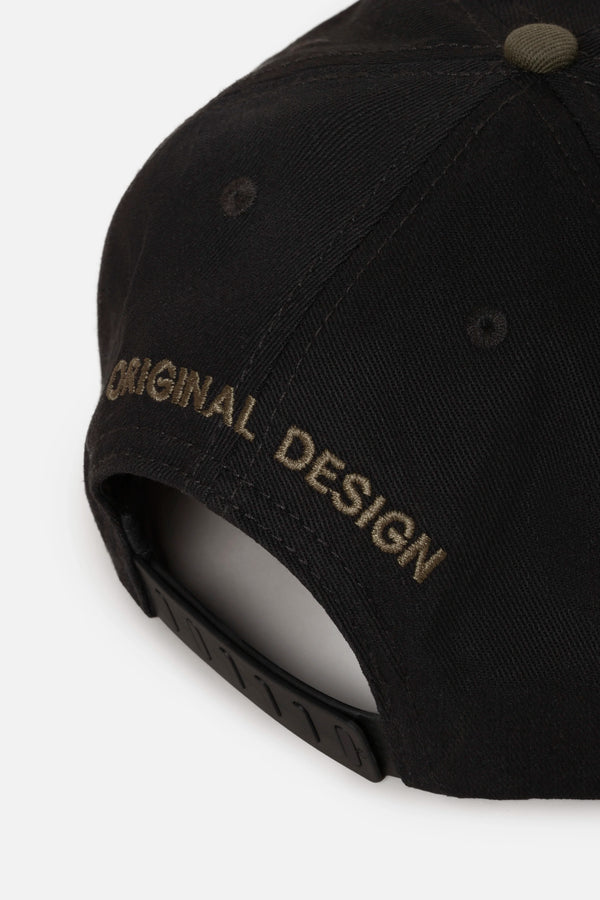 GORRA BEISBOLERA EN BLOQUES DE COLOR CON BORDADO VERDE MARCA QUEST X JUAN FERNANDO QUINTERO