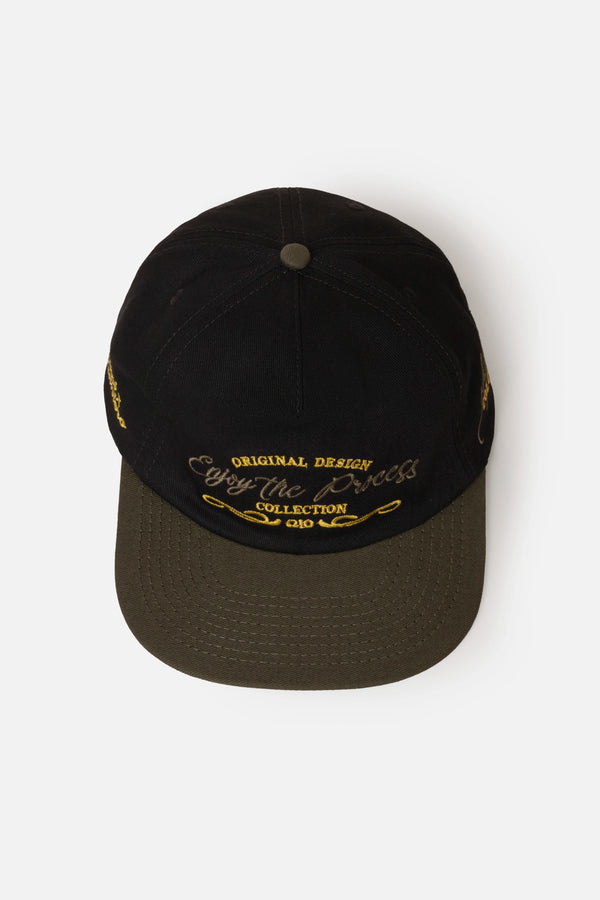 GORRA BEISBOLERA EN BLOQUES DE COLOR CON BORDADO VERDE MARCA QUEST X JUAN FERNANDO QUINTERO